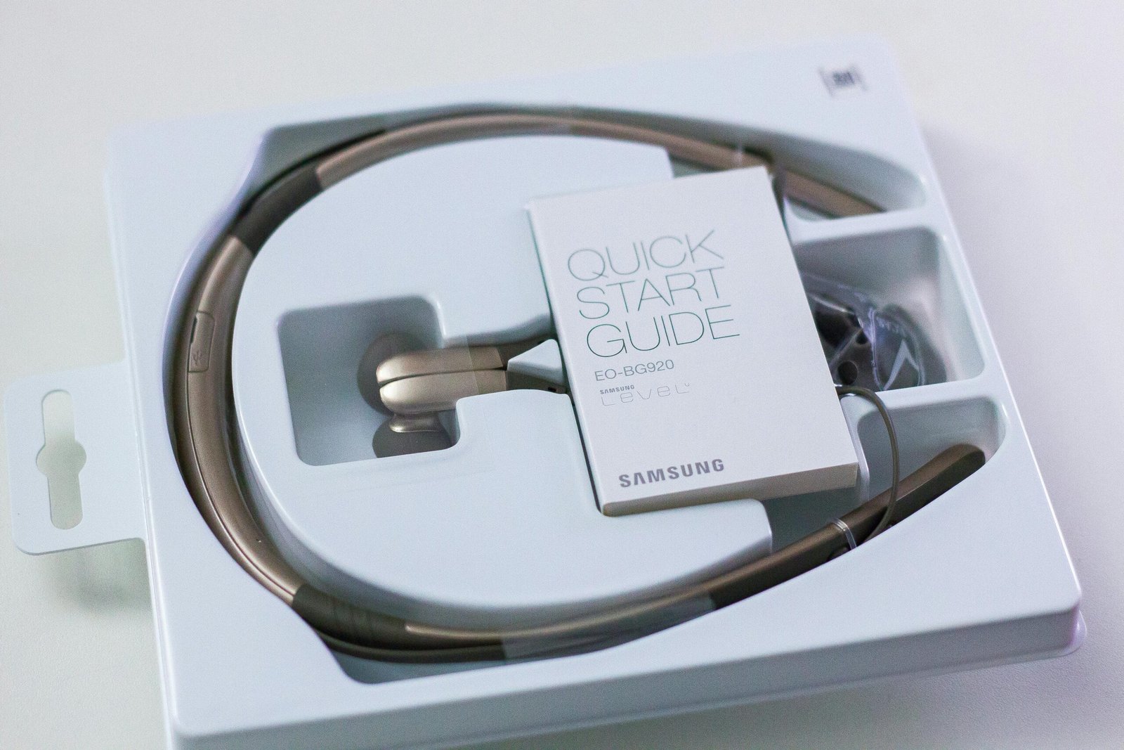 Close-up of Samsung wireless headphones with quick start guide in original packaging.