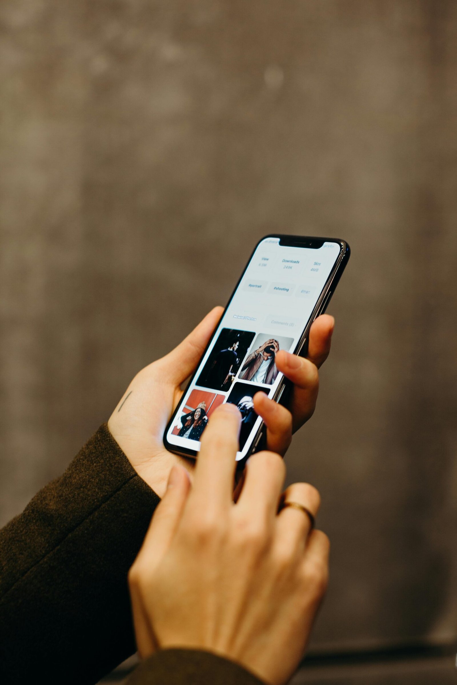 Close-up of hands using a smartphone to browse a photo gallery app, showcasing modern technology.